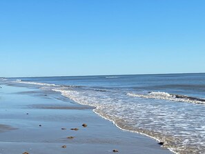 Uma praia com ondas quebrando suavemente na costa.