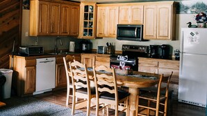 A spacious kitchen with wooden cabinets, a dining area with a table and chairs, and a staircase leading to an upper level. - June Lake Home with a view - 2bd / 2ba + loft (June Lake)