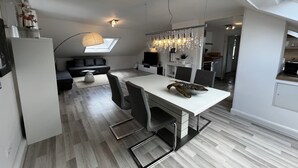 Una cocina moderna con comedor, horno empotrado y tragaluz.