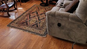 A living room with a leather sofa, a wooden cabinet, a television, and a patterned rug. - AZ Ranch House, near UofA & Banner Hosp /midtown (Tucson)