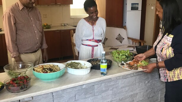 Una cucina con un piano di lavoro in pietra, diversi piatti di cibo e un frigorifero.