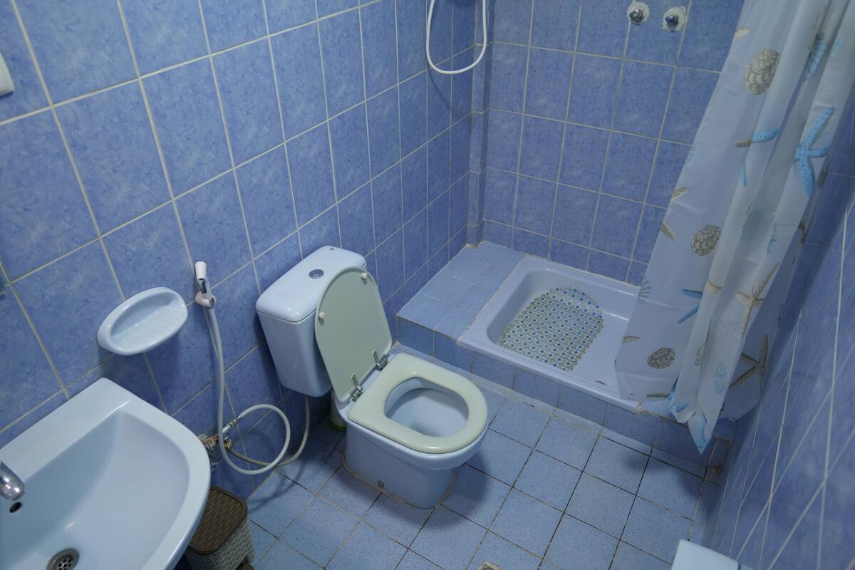 A bathroom with a toilet, bidet, and sink.