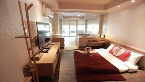 A hotel room with a bed, a TV, a desk, and a bathroom visible through an open door. - Wulai Shui An Hot Spring House (New Taipei City)