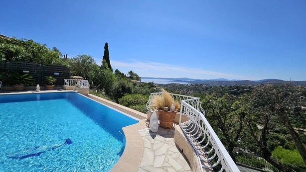 A swimming pool with a clear view of the surrounding landscape, including trees and distant hills. - Villa with swimming pool and sea view over the bay of St-Tropez. Air conditioning. (LES ISSAMBRES)