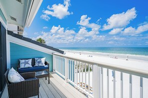 Ein Balkon mit Blick auf Strand und Meer.