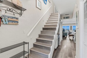 A staircase leading to a second floor with a view of the ocean. - 1 Step to the Beach! Beachfront Condo with 3 Sunset Decks, Sleeps 6 (Indian Rocks Beach)