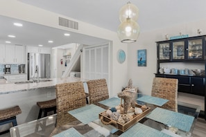 A modern kitchen with white cabinets, a stainless steel refrigerator, and a built-in oven. - 1 Step to the Beach! Beachfront Condo with 3 Sunset Decks, Sleeps 6 (Indian Rocks Beach)