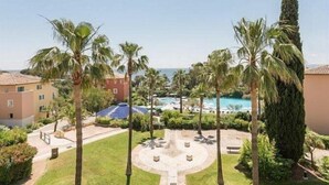 Un resort con piscina, palmeras y vista al océano.