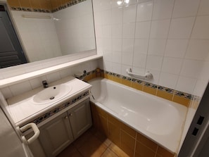 Ein Badezimmer mit Waschbecken, Badewanne und Spiegel.