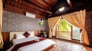 A spacious bedroom with a large bed, a wooden headboard, a nightstand, and a window with curtains. - Tamcoc Ngoc Linh Homestay (Nam Hoa Lu)