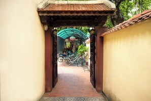 A narrow pathway leading to a covered area with bicycles parked.