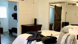 Ein Schlafzimmer mit einem Bett, Nachttischen, einem Spiegel und einem Kleiderschrank.