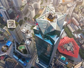 A high-rise building with a unique angular design, surrounded by other modern buildings.