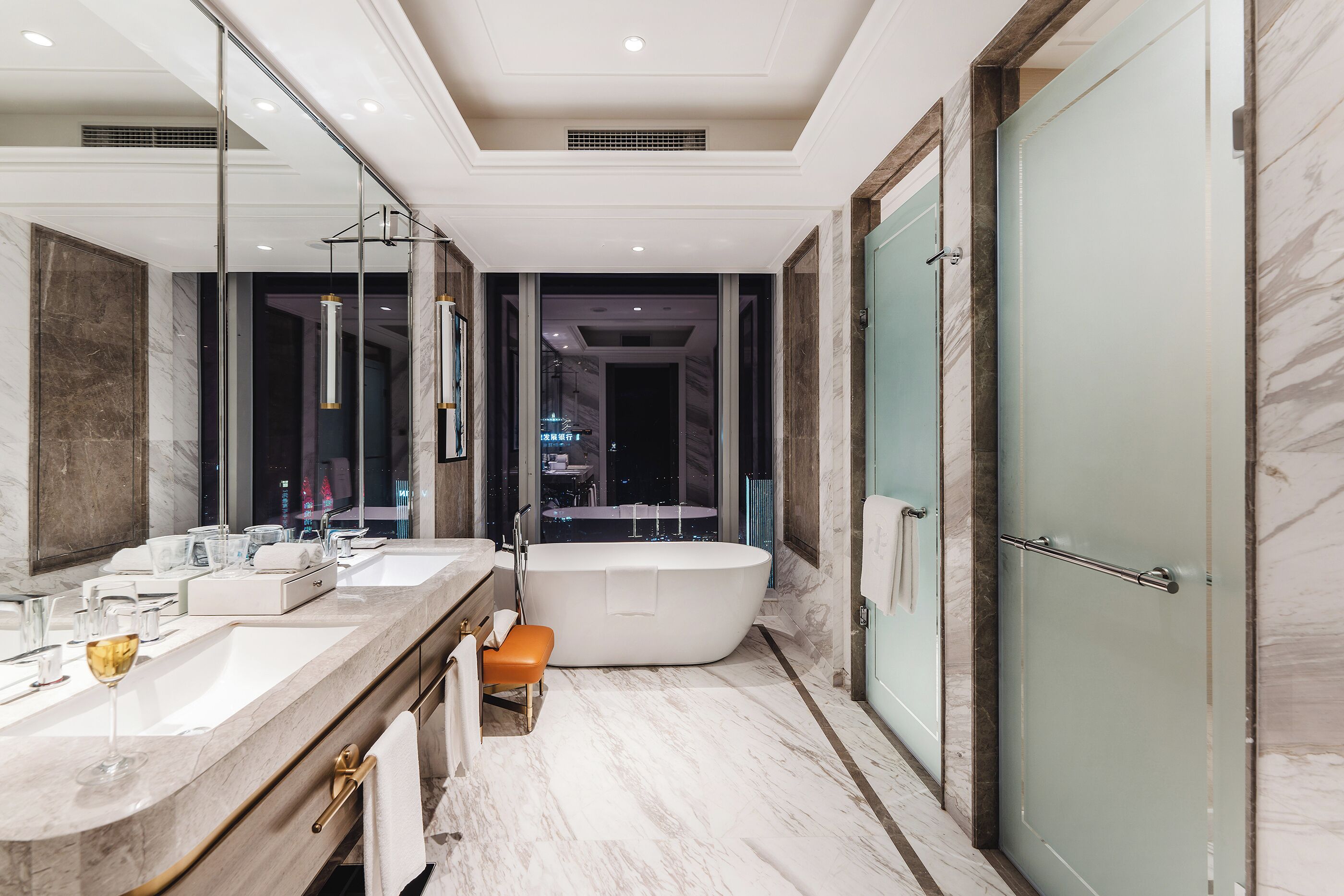 Une salle de bain moderne avec une baignoire sur pieds, deux vasques et un grand miroir.