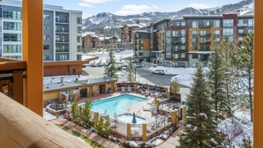 Ein Resort mit Pool, mehreren Gebäuden und einem verschneiten Berg im Hintergrund.