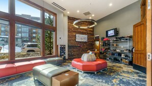 Eine moderne Lobby mit Sitzgelegenheiten, einem Fernseher und einer Schuhpräsentation.