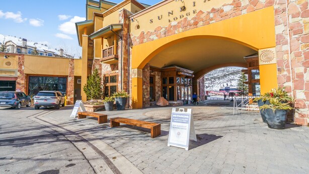 Ein Gebäude mit einer steinernen Fassade und einem Bogen, auf dem „SUNDIAL LODGE“ steht.