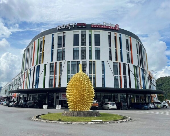 A hotel with a modern design, featuring a large golden sculpture in front.
