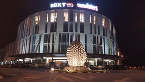 Ein Hotel mit modernem Design, vor dem eine große, einzigartige Skulptur steht.