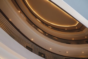 Interior com vários níveis, balcões curvos e iluminação embutida.