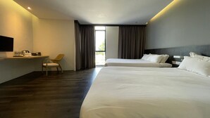 Ein Hotelzimmer mit zwei Betten, einem Schreibtisch, einem Stuhl und einem Fernseher.