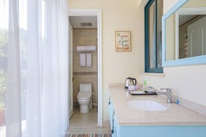 Een badkamer met toilet, wastafel en handdoekrek.