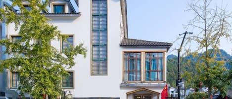 A two-story building with a traditional architectural style, featuring a prominent vertical window and a tiled roof.
