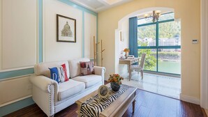 Un salon avec un canapé blanc, une table basse à motifs zébrés et un tableau encadré accroché au mur.