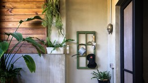 A small, enclosed outdoor space with a wooden wall, a concrete bench, and various potted plants. - Nanwanps (Hengchun)
