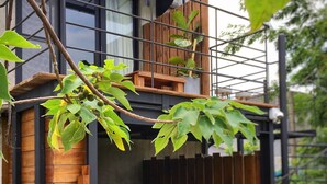 A modern building with a wooden deck and a metal railing. - Nanwanps (Hengchun)