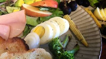 A plate with various foods including eggs, vegetables, and bread.