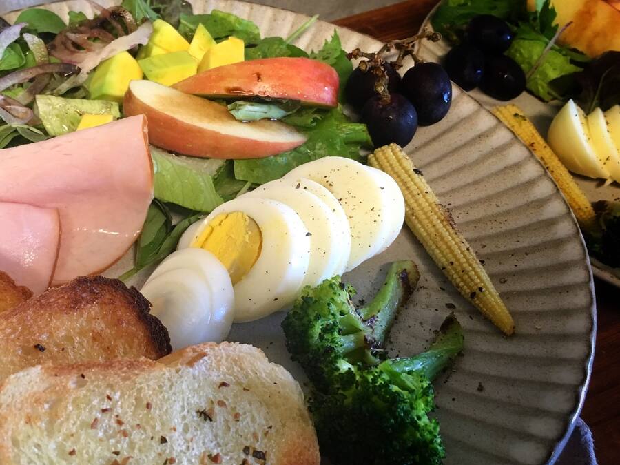 A plate with various foods including eggs, vegetables, and bread.