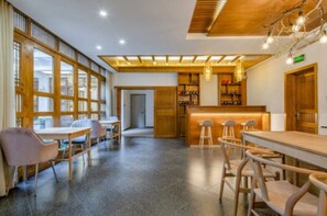 A spacious indoor area with a long counter, several tables, and chairs.
