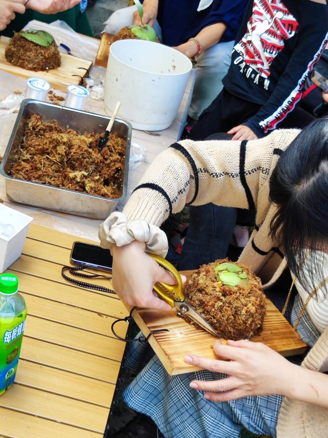 A person cutting a food item on a wooden board.