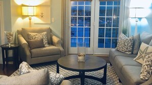 A living room with a ceiling fan, two sofas, a coffee table, and a rug.