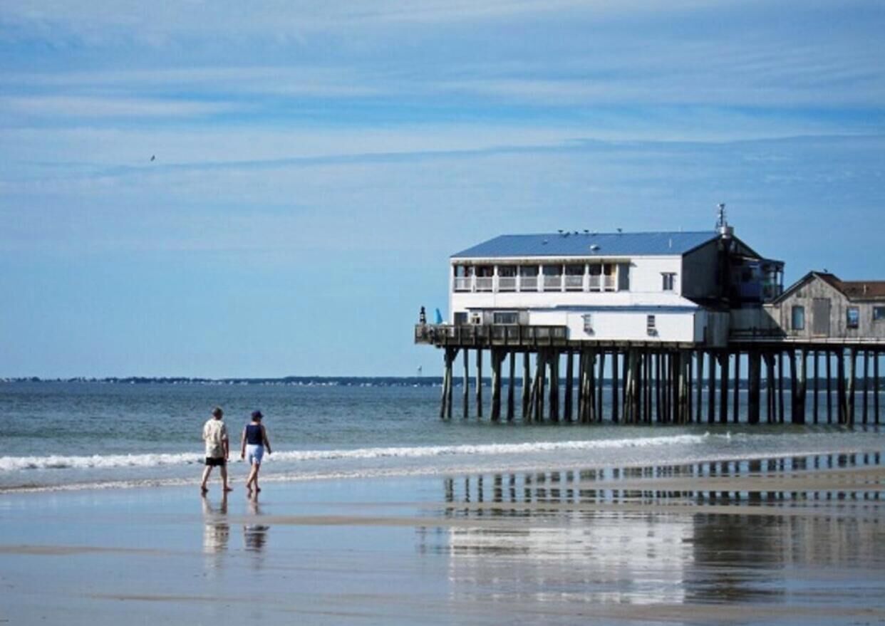 A pier extending into the water with a building on top, likely a restaurant or cafe, and a small lighthouse structure.