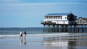 A pier extending into the water with a building on top, likely a restaurant or cafe, and a small lighthouse structure.