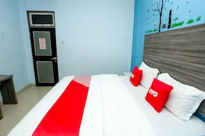Una habitación de hotel con una cama, una mesita de noche, una puerta y una pared con un mural.