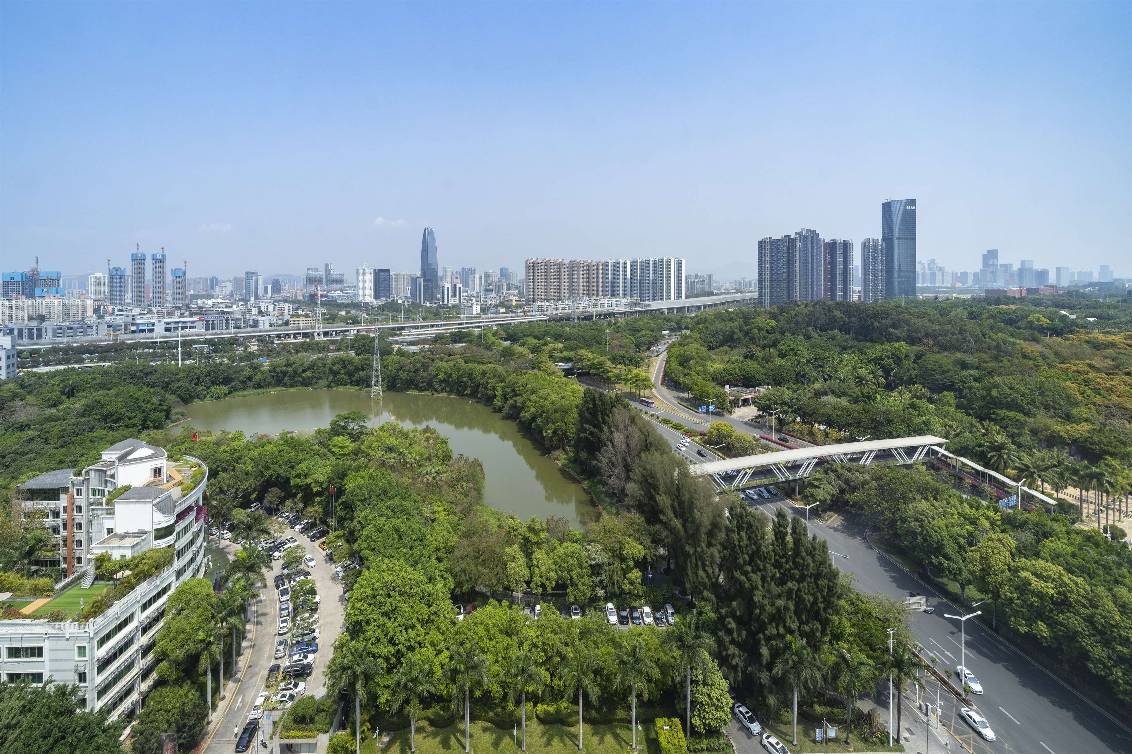 Un paisaje urbano con un río, zonas verdes y edificios modernos.