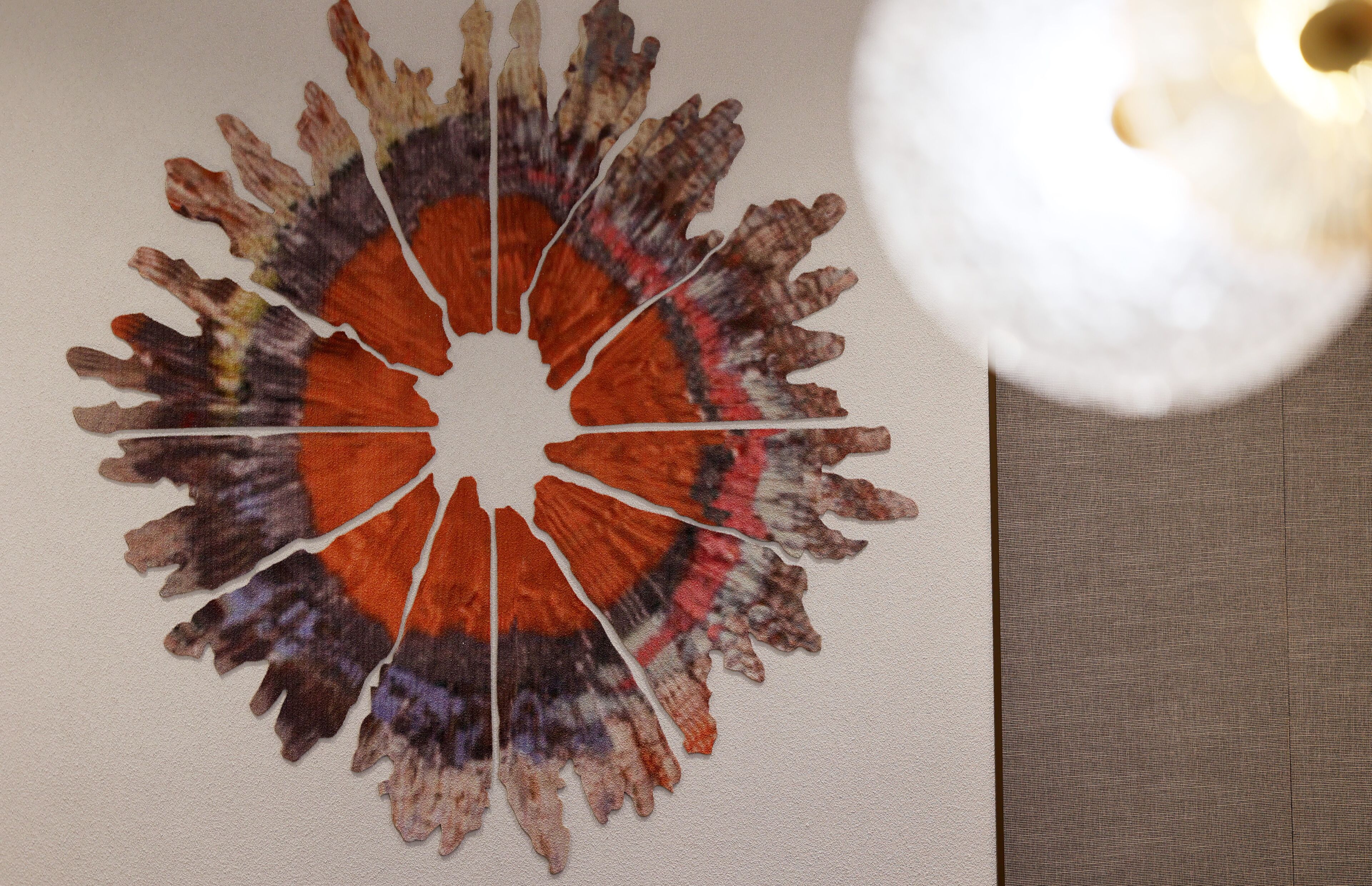Una obra de arte mural circular con un agujero central, posiblemente para colgar.