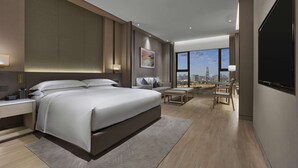 A modern hotel bedroom with a large bed, bedside tables, a desk, and a city view. - DoubleTree by Hilton Shenzhen Nanshan Hotel & Residences (Shenzhen)