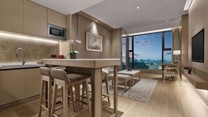 A modern kitchen with a built-in microwave, a bar area with stools, and a large window offering a city view. - DoubleTree by Hilton Shenzhen Nanshan Hotel & Residences (Shenzhen)