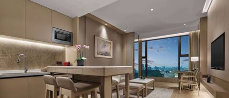 Una cocina moderna con microondas integrado, una barra con taburetes y un ventanal con vistas a la ciudad.