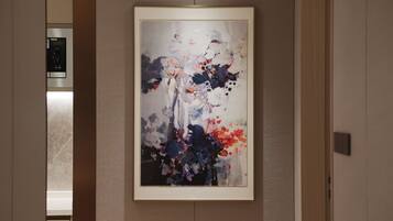 Une peinture abstraite encadrée est accrochée au mur d’une chambre d’hôtel.
