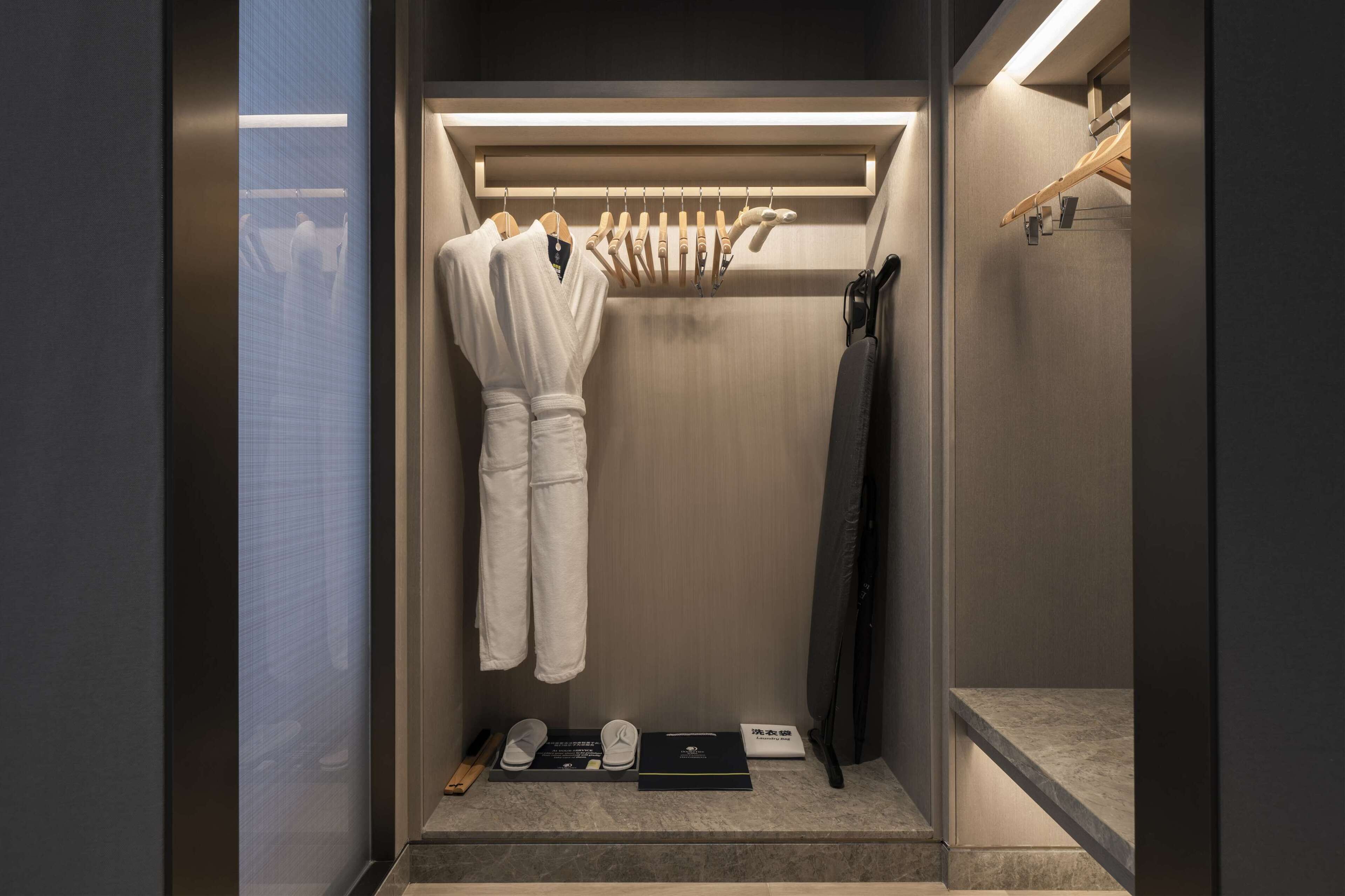 A modern bathroom with a built-in shower, a robe rack, and a towel rack.
