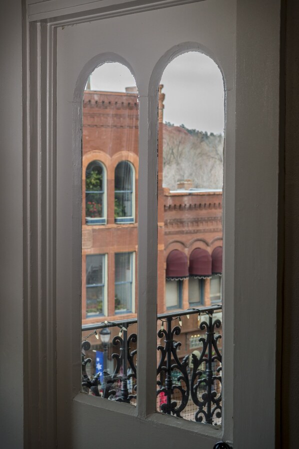 Enjoy the view from this balcony with arched windows and a brick facade.