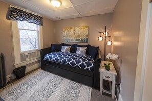 Relax in this serene space with a modern bed, a bedside table, and a potted orchid.