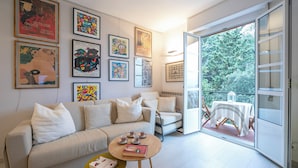 A modern living room with a sofa, coffee table, and a balcony with a table and chairs. - Cervo Piccolo Incanto Apartment with Balcony, Cervo, Italy (Cervo)