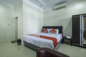A bedroom with a bed, a wardrobe, and a small table with towels. - OYO 2259 Zleepy Ks Tubun (North Cirebon)