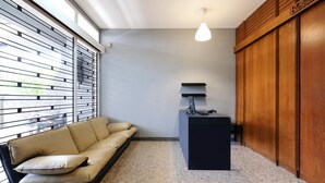 A modern living room with a sofa, a small table, a lamp, and a wooden cabinet. - SPOT ON 2281 Omajo (Semarang)